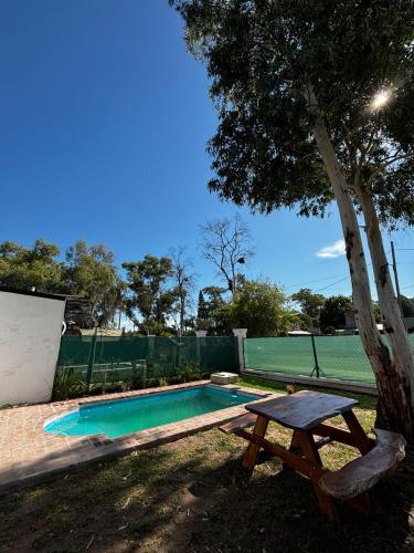 a swimming pool with a picnic table next to a tree at Rincon de Tucuns in San José del Rincón