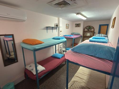 a room with two bunk beds and a mirror at The Shelter Hostel Eilat in Eilat