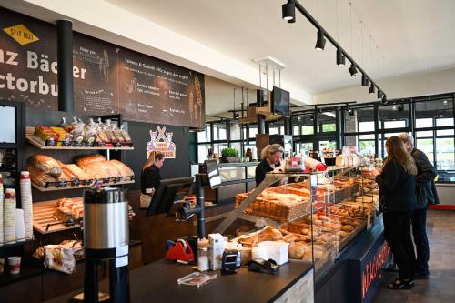 a group of people standing at a counter in a bakery at Sleep Space 24 - Green Tiny Spot Schillig in Wangerland