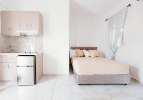 a small white room with a bed and a kitchen at Villa Theano 2 in Toroni