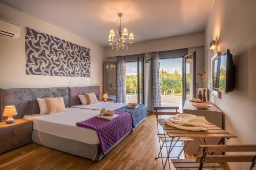 a bedroom with a bed and a table with two beds at Astarte Villas - Istar Villa with Tennis Court in Makhairádhon