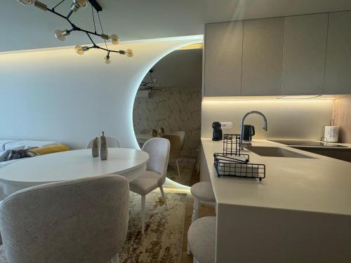 a kitchen with a white table and chairs in a room at Apulia Seawind in Apúlia