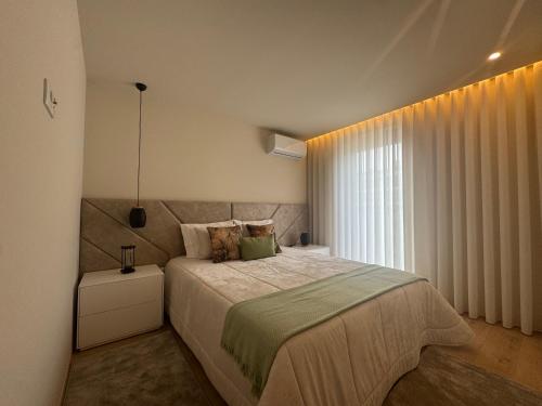 a bedroom with a large bed and a window at Apulia Seawind in Apúlia