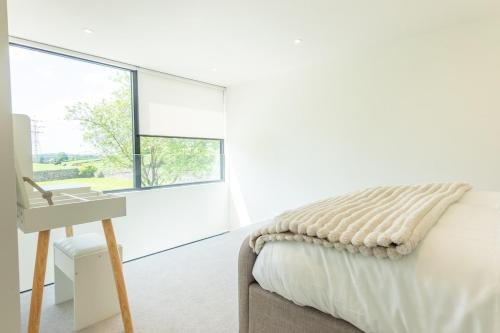 a bedroom with a bed and a sink and a window at The Studio at Cherry Tree in Natland