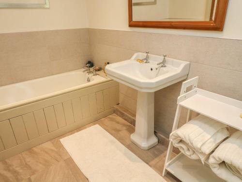 a bathroom with a sink and a bath tub and a sink at Litton Hall Barn Cottage in Skipton