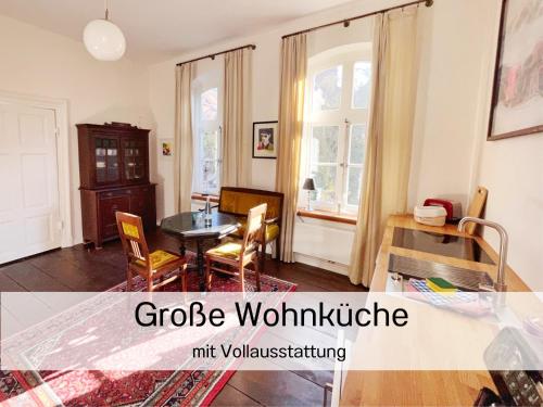 ein Wohnzimmer mit einem Tisch und ein Esszimmer in der Unterkunft FeWo "Ebbe" im historischen Denkmal, ruhig & modern mit Stil, Kunst und großem Garten, hochwertiger Ausstattung & zentraler Lage in Esens- 3km zur Nordsee, alles fußläufig erreichbar - ideal für Paare oder kleine Familien in Esens