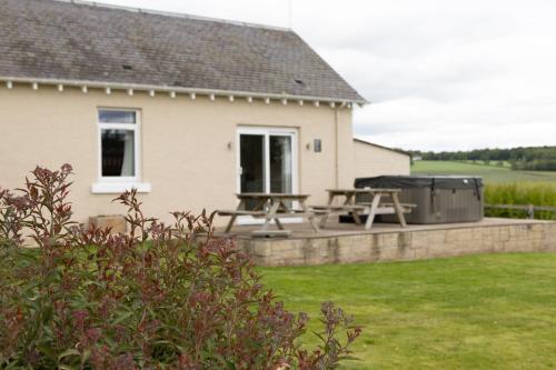 a backyard with a picnic table and a grill at Bachilton Farm Holidays in Perth