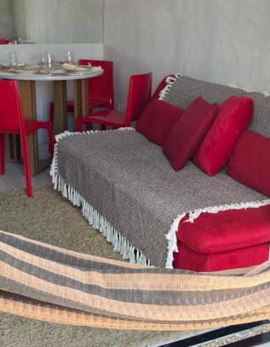 a bedroom with a bed with red pillows and a table at Flat em Gravatá in Gravatá