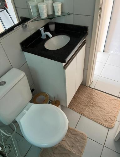 a bathroom with a white toilet and a sink at Flat em Gravatá in Gravatá