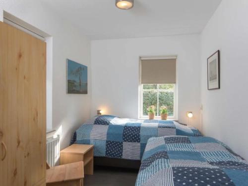 a bedroom with two beds and a window at Christoffellaan 101 in Brouwershaven