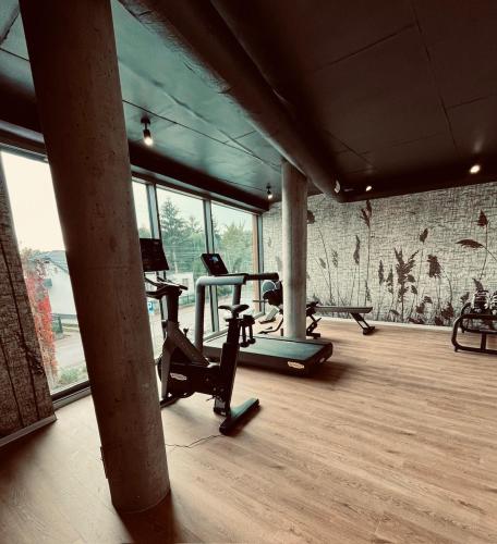 a gym with two exercise bikes and a brick wall at Apartamenty prywatne przy Samej Wodzie w Riva Zegrze - Jezioro Zegrzyńskie in Zegrze Południowe