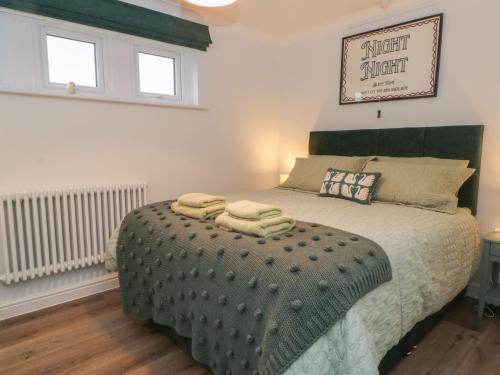 a bedroom with a bed with two towels on it at Moorview in Holmfirth