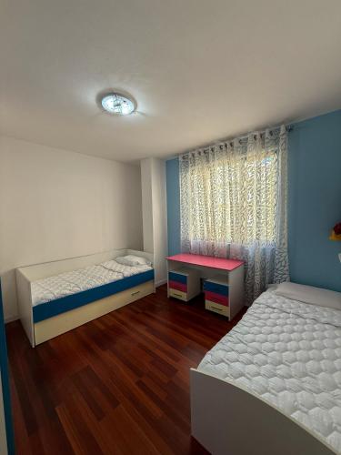 a bedroom with two beds and a window at Sea View Apartment in Durrës