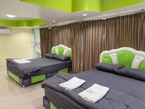two beds in a room with green and purple at Martin, Local Guide & Camping in Ban Phang Kan Nua