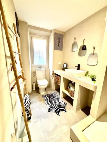 a bathroom with a sink and a toilet at Le Safari - Montélimar in Montélimar