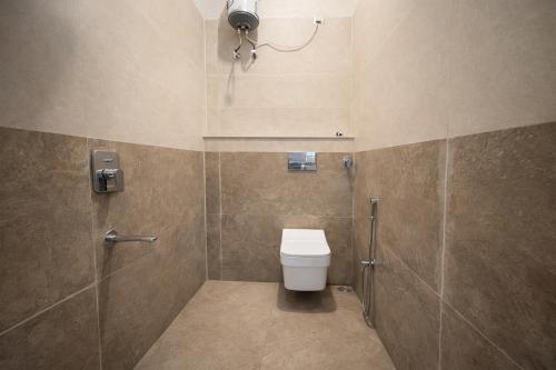 a bathroom with a toilet and a shower at Hotel Blueberry Bhedaghat in Jabalpur