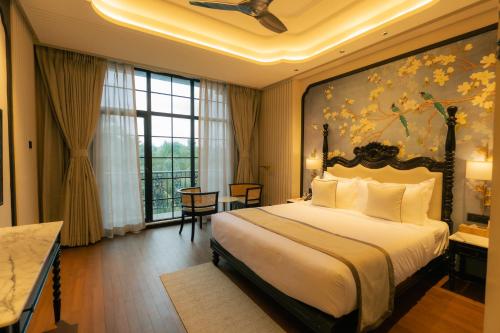 a bedroom with a large bed with a painting on the wall at Seashell Samssara Havelock in Havelock Island