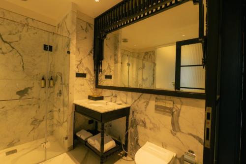a bathroom with a sink and a shower and a mirror at Seashell Samssara Havelock in Havelock Island