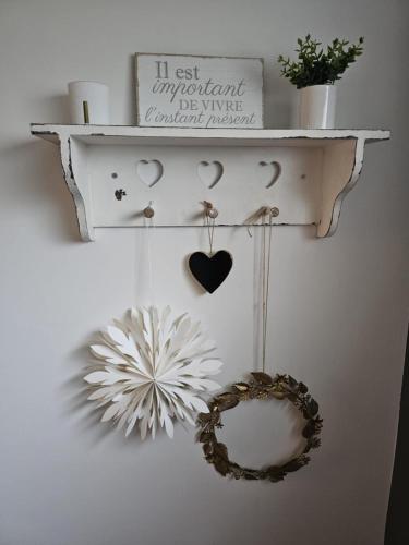 a shelf with hearts and a wreath on a wall at L'envol des oies in Braives