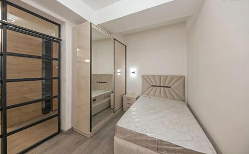 a small bedroom with a bed and a mirror at Zvartnots International Hotel in Pʼarakʼar