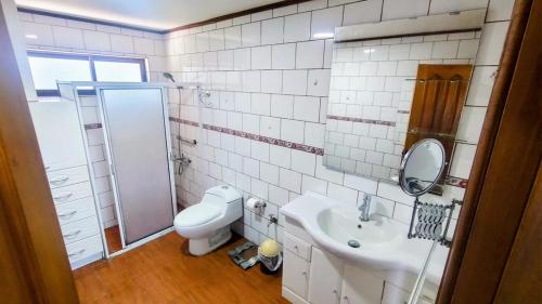 a bathroom with a toilet and a sink and a shower at Casa Quinta el Labrador Renaico in Estación Roblería
