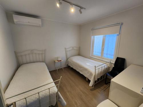 a small room with two beds and a window at The Lakeview Cottage near Shiroka center in Shirokë