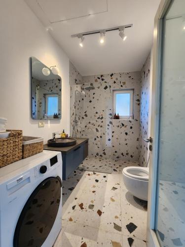 a bathroom with a toilet and a sink at The Lakeview Cottage near Shiroka center in Shirokë