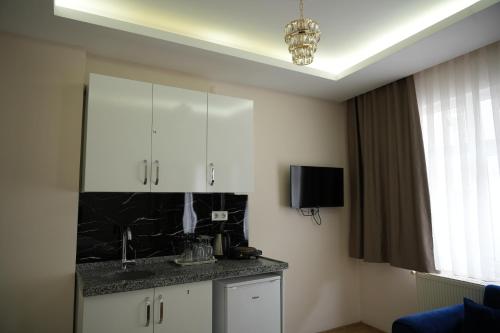 a kitchen with white cabinets and a black counter top at BDK hotel in Istanbul