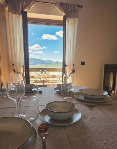 a table with wine glasses and a table with a view at Attico e super attico panoramico in Rocca di Cambio