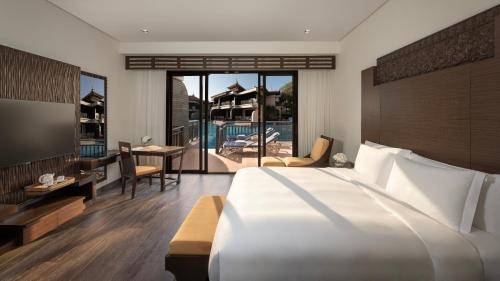 a bedroom with a large bed and a desk and a table at Anantara The Palm Dubai Resort in Dubai