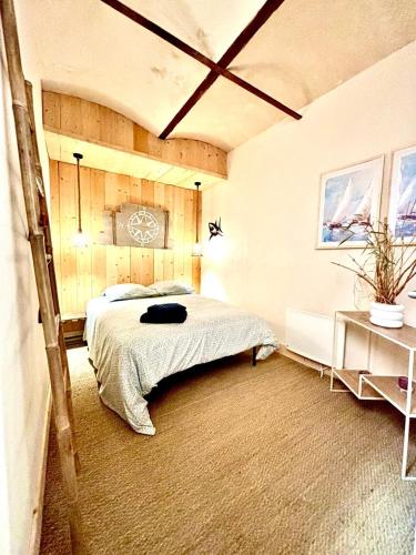 a bedroom with a bed and a table in it at Le Gouvernail - Montélimar in Montélimar
