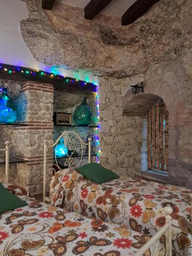 a bedroom with two beds and a stone wall at AL CANTINONE in Toffia
