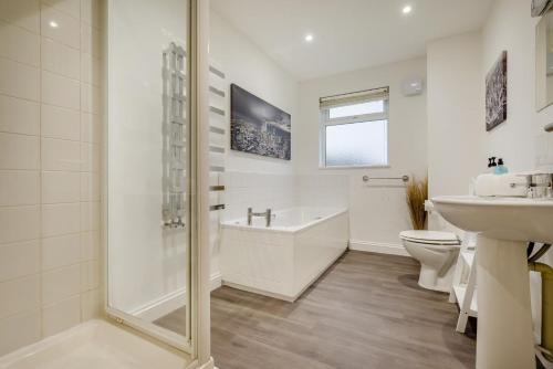 a bathroom with a tub and a toilet and a sink at 4 Bed in Winnards Perch oc-w34023 in Saint Columb Major