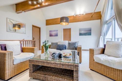 a living room with wicker chairs and a table at 4 Bed in Winnards Perch oc-w34023 in Saint Columb Major