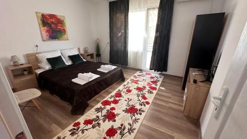 a bedroom with a bed with a floral blanket on it at Apartment ADELINA in Tsarevo