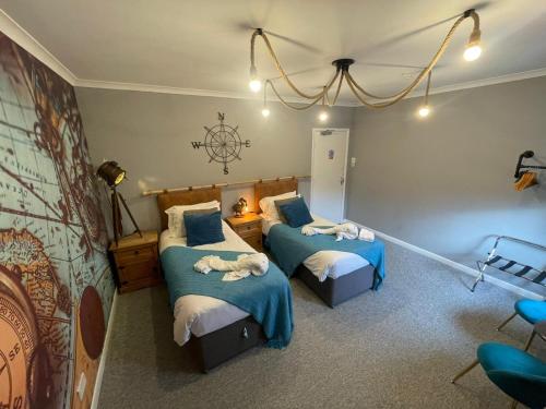 a bedroom with two beds with blue and white sheets at The Riverside inn in Saltford
