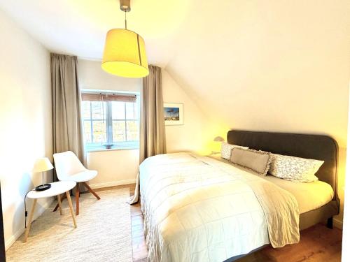 a bedroom with a bed and a chair and a window at Ferienhaus 1 Fuchsweg in Stralsund