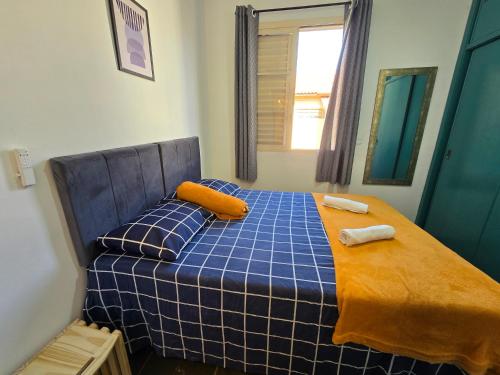 a bedroom with a blue bed with orange pillows at Jaboticabal 403A in Jabuticabal