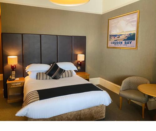 a hotel room with a large bed and a table at The Dutch Mill Hotel in Aberdeen