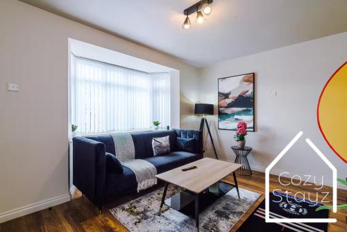 a living room with a couch and a table at Spacious 3 Bed with Pac-Man, Darts and 2 Parking spaces in Manchester