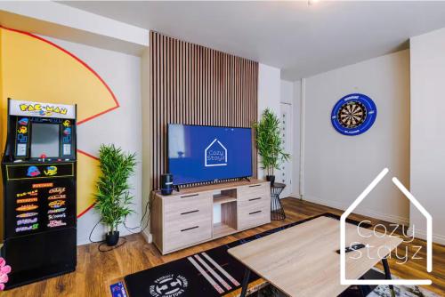 a living room with a tv and a video game at Spacious 3 Bed with Pac-Man, Darts and 2 Parking spaces in Manchester