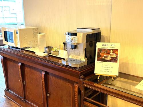 a counter with two coffee machines on top of it at Hotel Il Viale Hachinohe Annex in Hachinohe