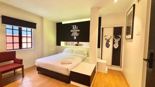 a small bedroom with a bed and a chair at Star Mews Hotel Changkat Bukit Bintang in Kuala Lumpur
