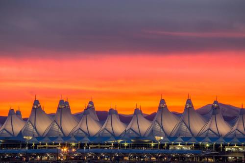 a large building with a sunset in the background at Baymont by Wyndham Denver International Airport in Denver
