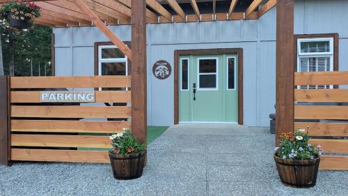a building with a wooden fence and a door at Quadra Island Mist in Quathiaski Cove