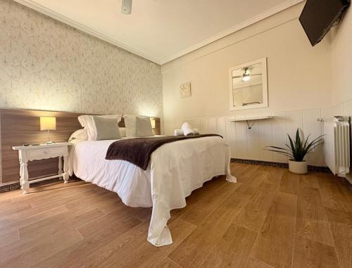 a bedroom with a large bed with a wooden floor at Hospedaje Javier in Isla
