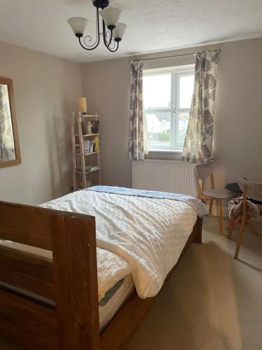 a bedroom with a bed and a window and a table at Pine Tree Cottage in Linslade