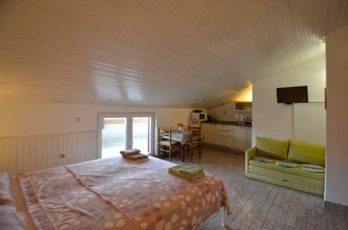 a bedroom with a bed and a kitchen with a table at GALANT apartments in Rovinj