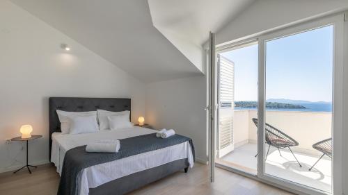 a bedroom with a bed and a balcony with the ocean at Villa Julija by Villas Guide in Smokvica