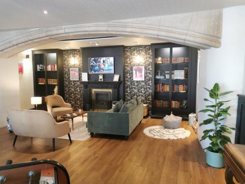 a living room with a couch and a fireplace at Hôtel Le Normandy - Maison Tassoni in Vernon